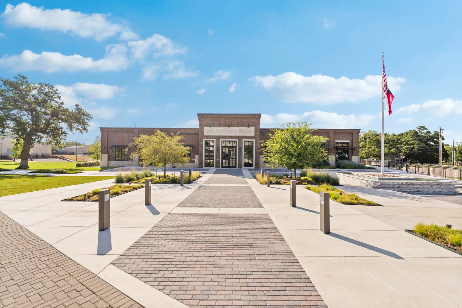 Burnet City Hall with a landscaped plaza, broad walkways and Texas and American flags