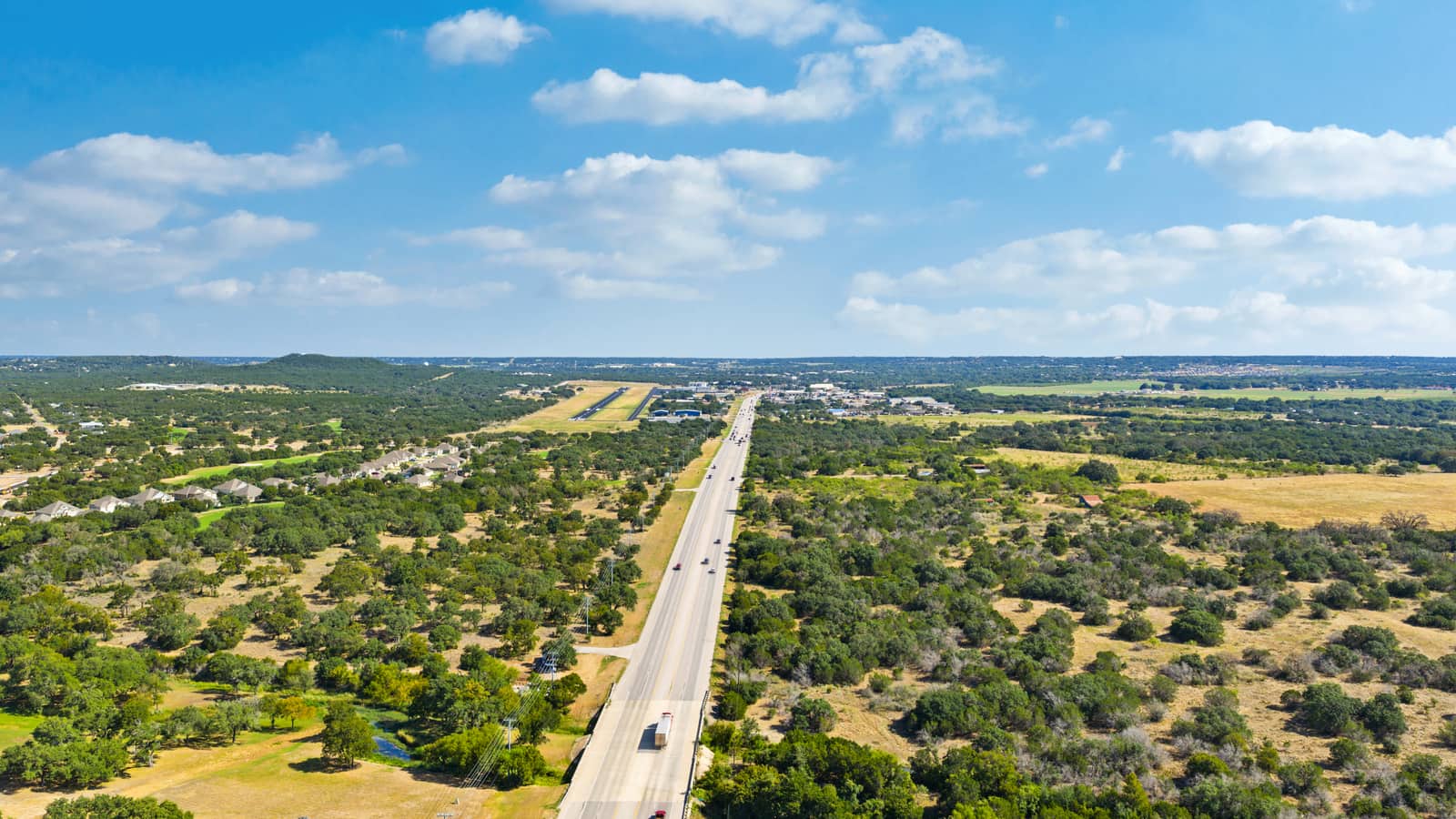 Aerial view of the road into Burnet with wooded Hill Country and open sky