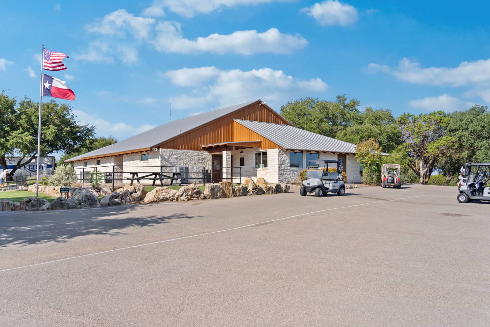 The stone and wood clubhouse at Delaware Springs with golf carts outside