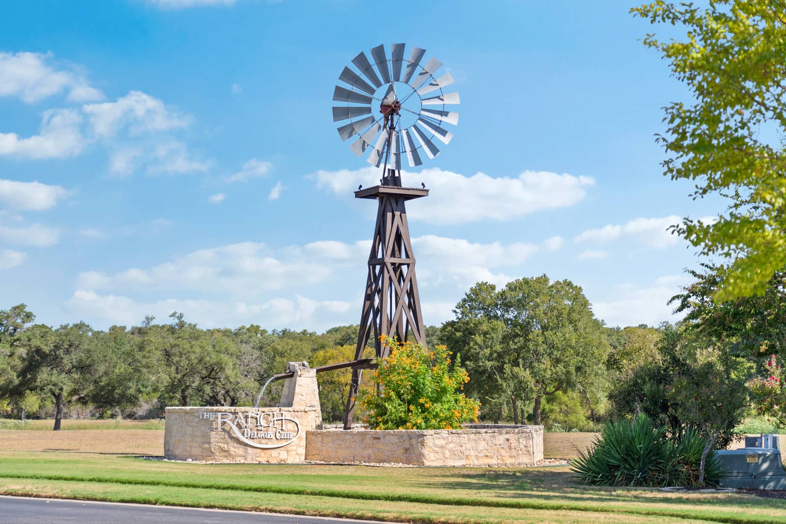 The windmill and limestone entrance to The Ranch at Delaware Creek