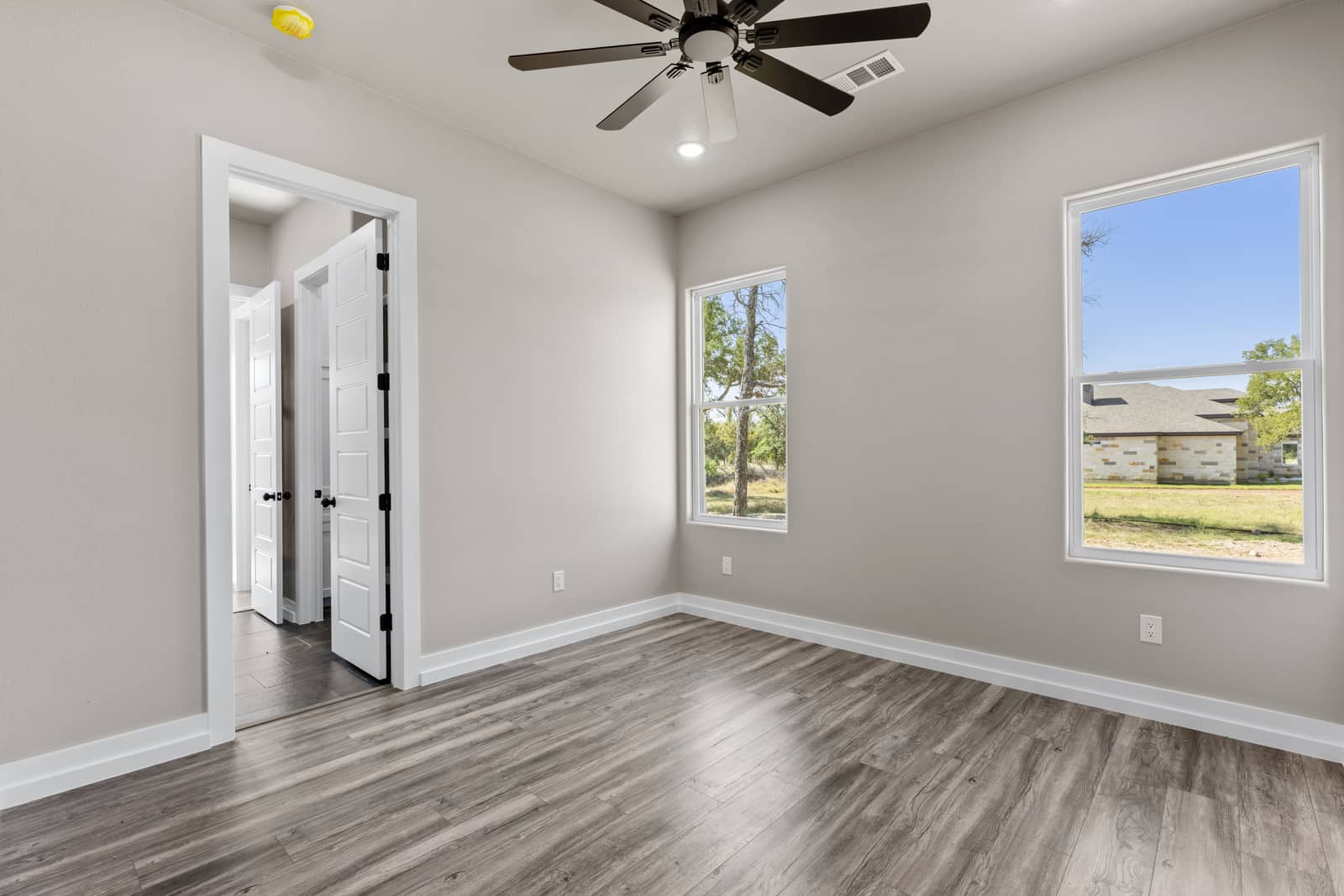 Bright bedroom with corner windows and a ceiling fan at 258 Sunday Drive
