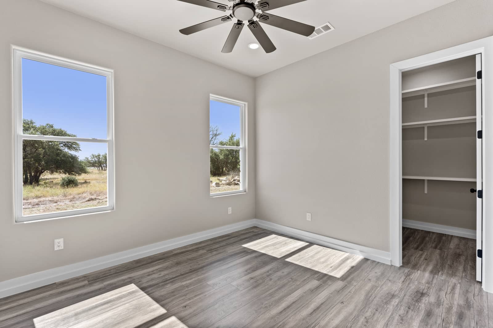 Bedroom with two windows and built-in closet shelving at 258 Sunday Drive