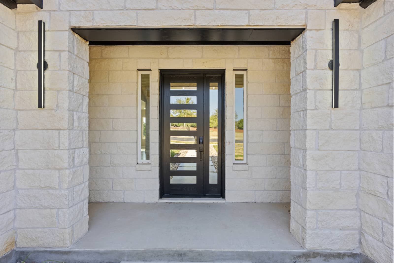 Contemporary front door framed by limestone at 258 Sunday Drive