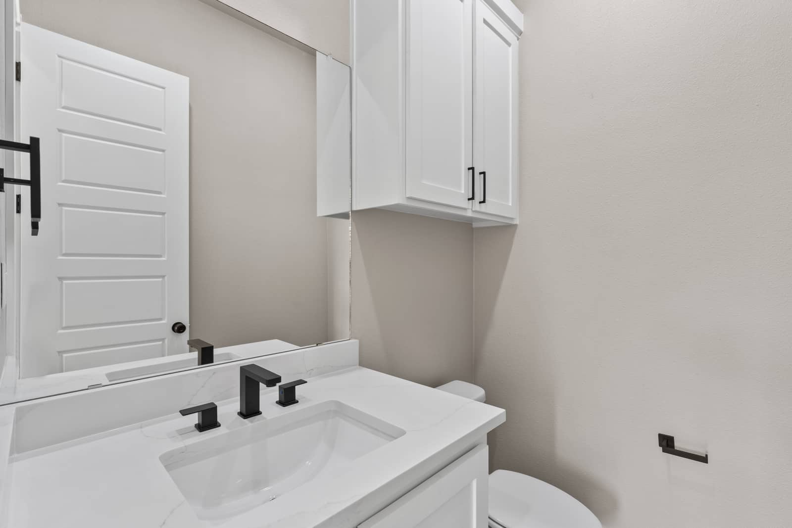 Compact bathroom vanity with a dark faucet and white cabinetry at 258 Sunday Drive
