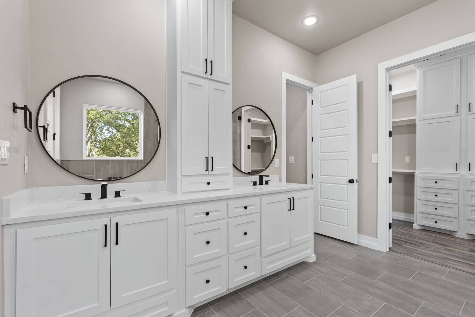 Double vanity with round mirrors and built-in storage at 258 Sunday Drive