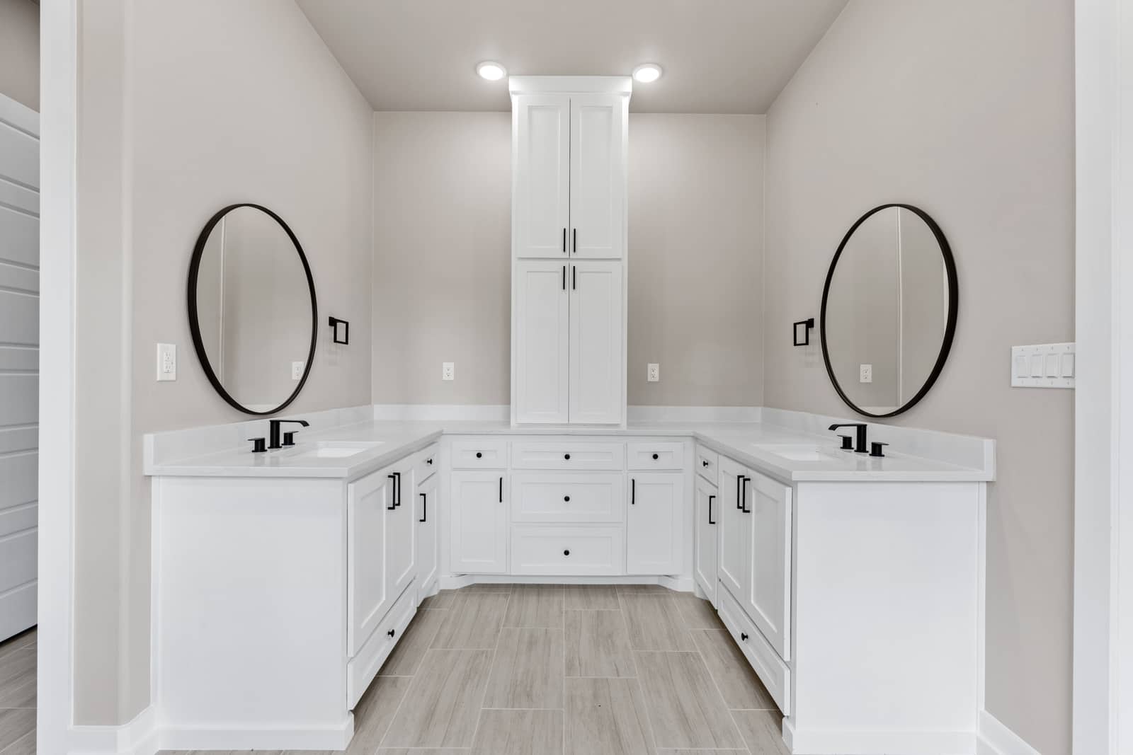 Bathroom vanity with paired mirrors and white storage cabinets at 262 Sunday Drive