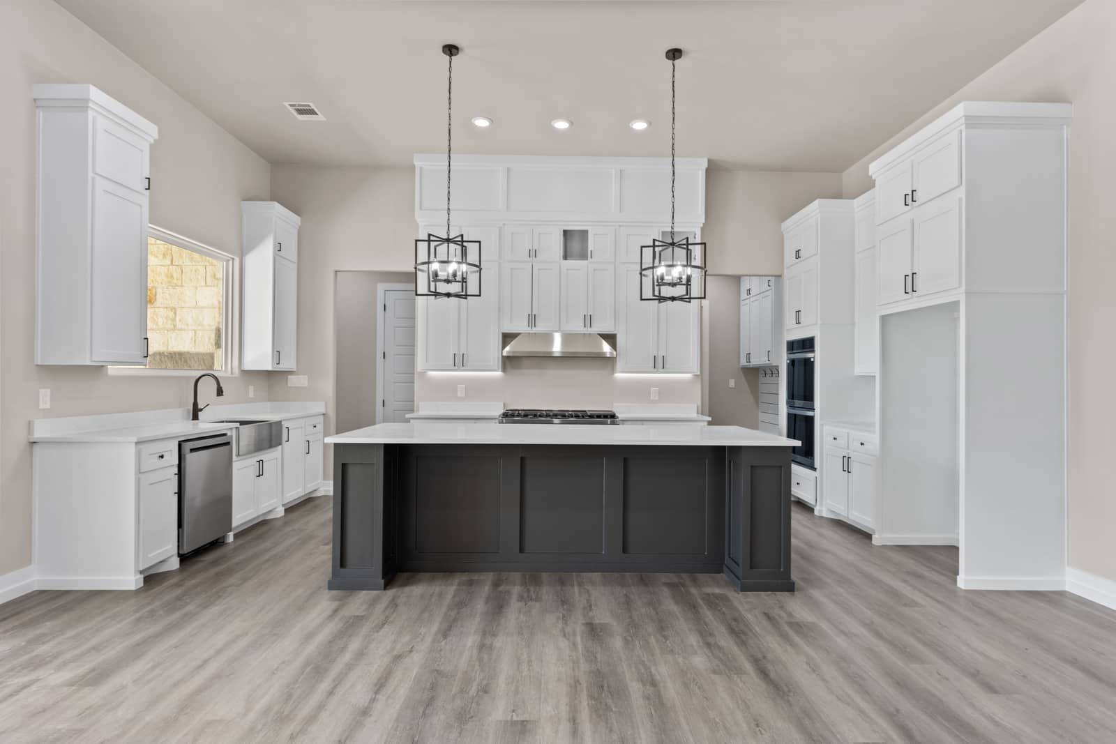 White kitchen with a dark island at 262 Sunday Drive