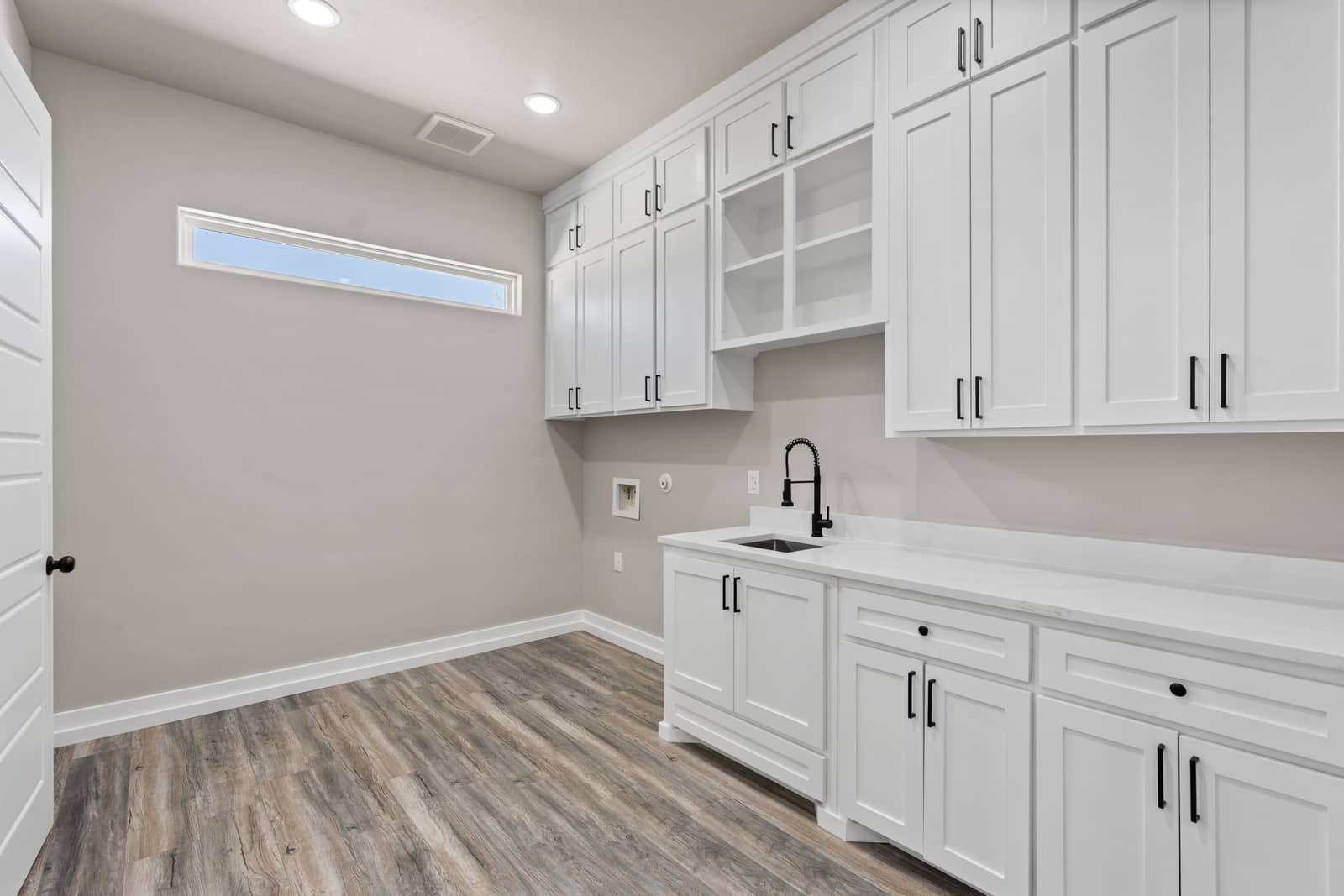 Laundry room with a sink, cabinets and a high window at 265 Sunday Drive