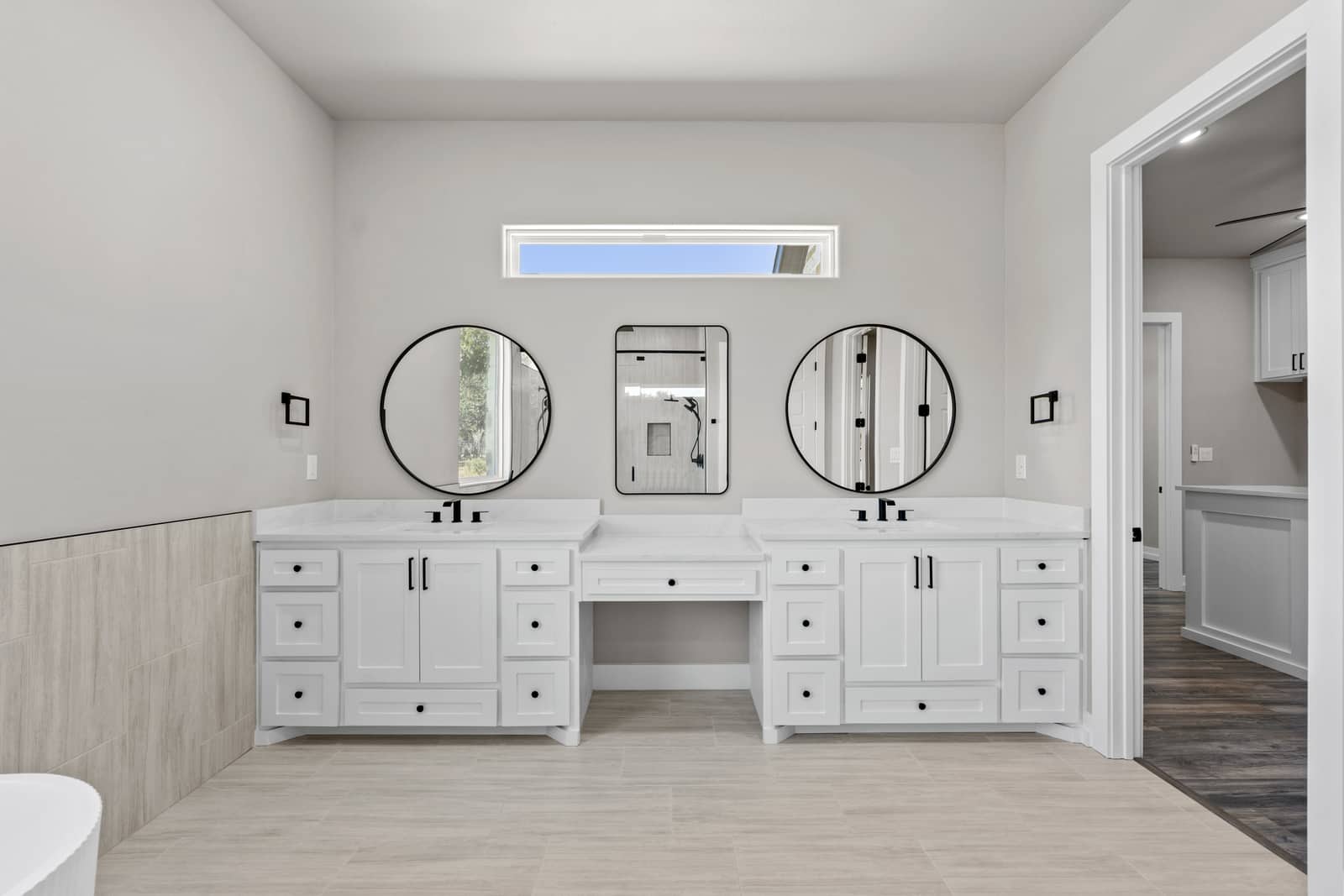 Double vanity with round mirrors and a central dressing counter at 265 Sunday Drive