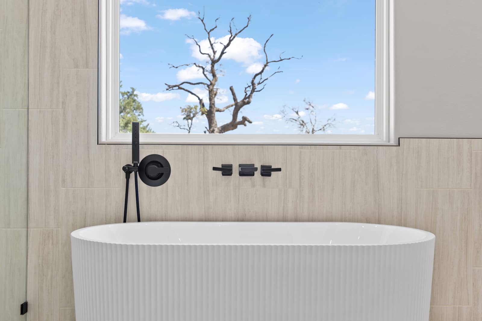 Fluted freestanding tub with black wall-mounted fixtures at 265 Sunday Drive