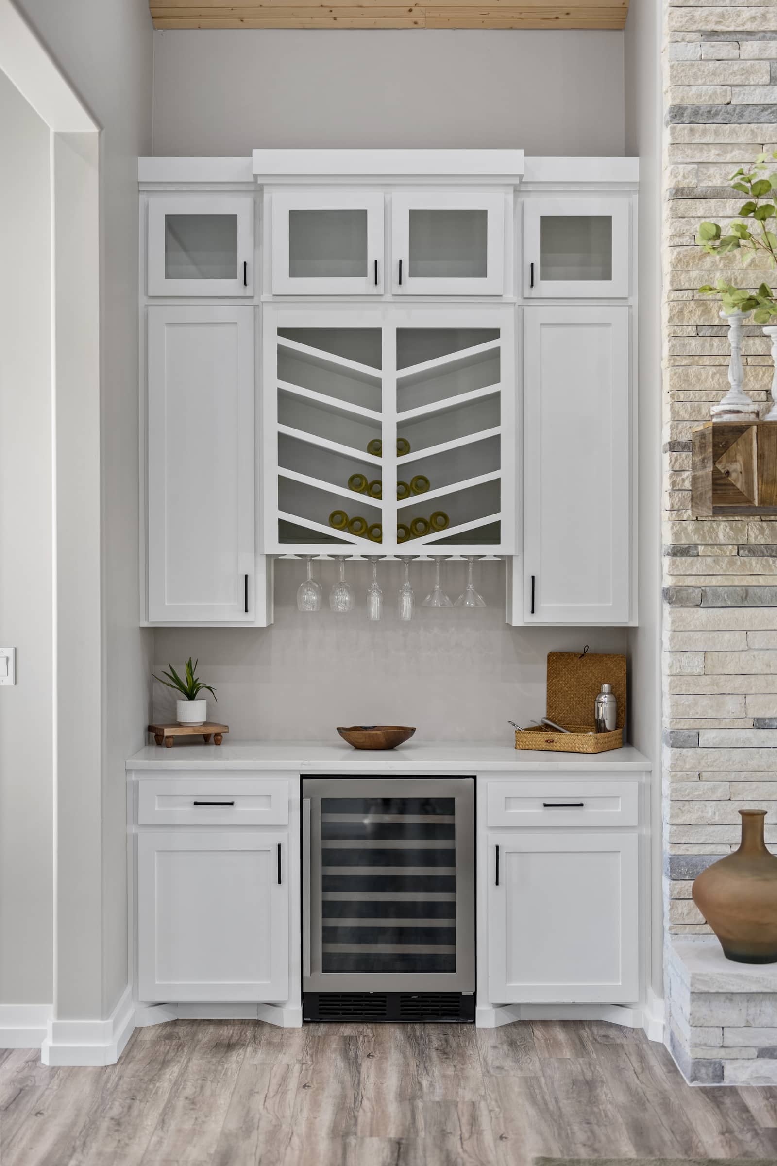 Built-in beverage cabinet beside the stone fireplace at 271 Sunday Drive