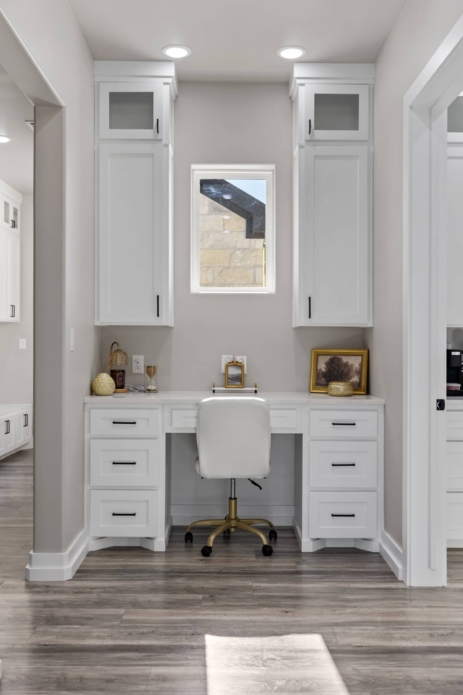 Built-in white desk with overhead cabinets and a window at 271 Sunday Drive