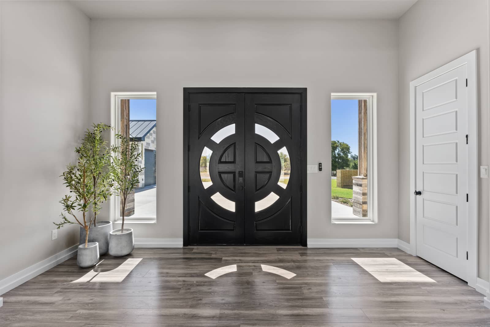 Black circular double entry doors framed by narrow windows at 271 Sunday Drive