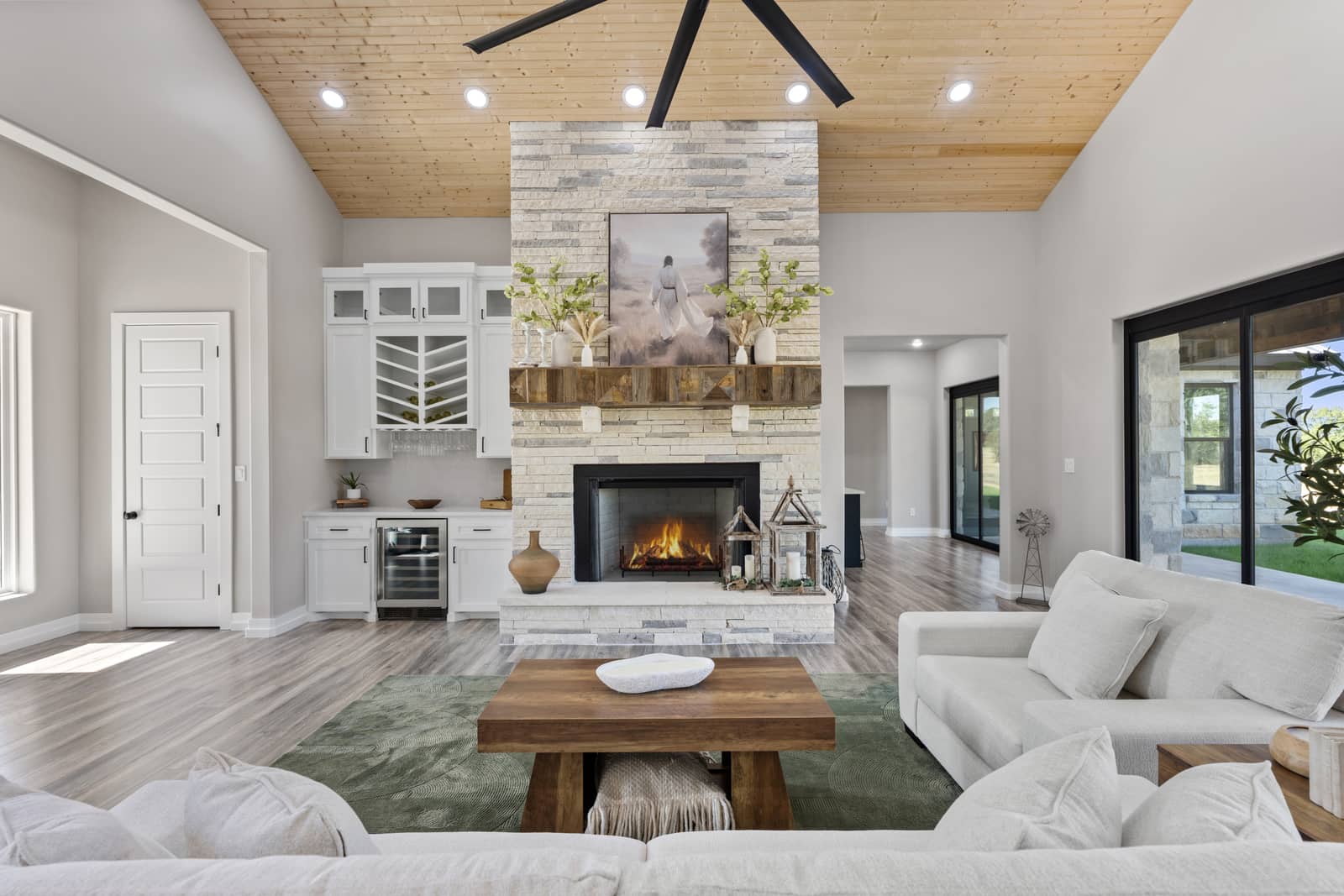 Furnished living room with a limestone fireplace and warm wood ceiling at 271 Sunday Drive