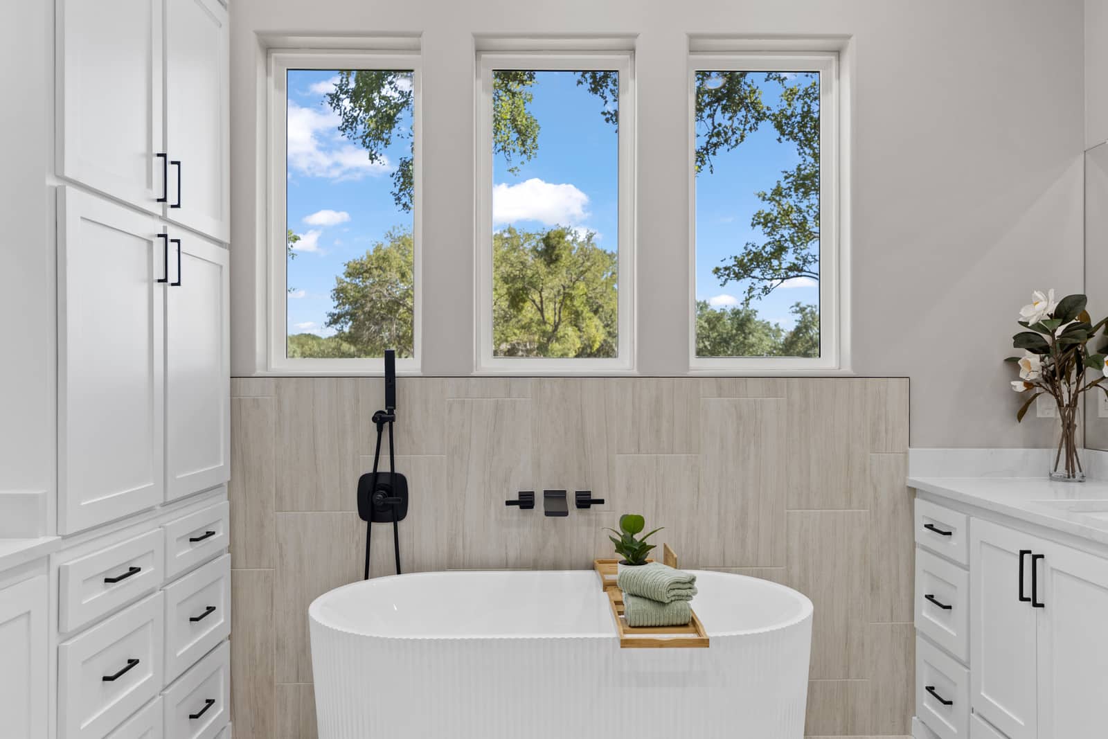 Freestanding tub framed by tall windows at 271 Sunday Drive