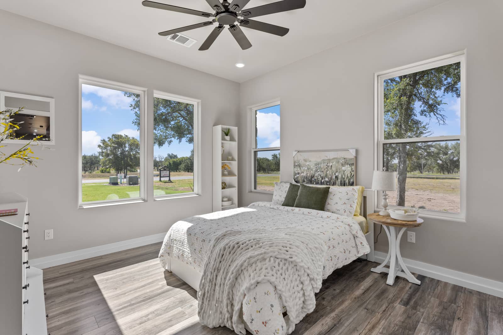 Furnished bedroom with corner windows and a floral bedspread at 271 Sunday Drive