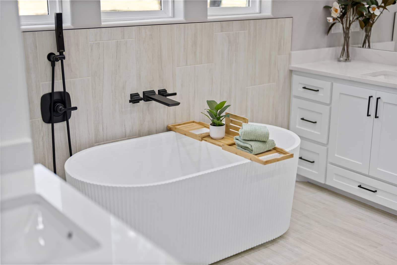 Fluted soaking tub with wall-mounted black fixtures at 271 Sunday Drive